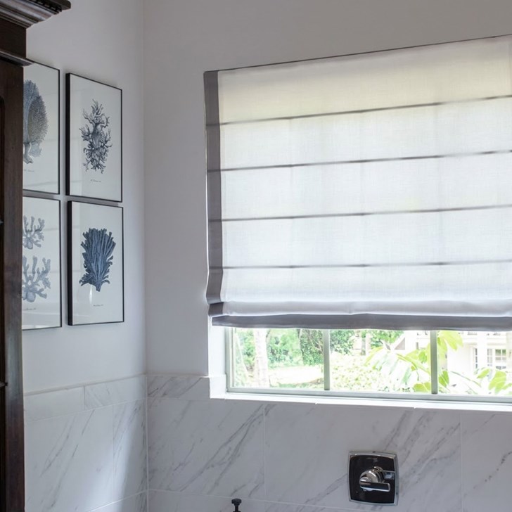 Light filtering roman shade with seams and edge banding.